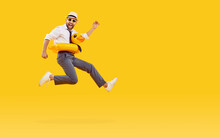 Funny Happy Man In Office Clothes, Sunglasses And With Duck Rubber Ring Is Going On Summer Holiday Trip And Having Fun Jumping On A Yellow Background With Copy Space. Vacation And Travel Concept.