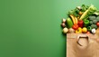 Top view paper bag full of different healthy food isolated on green background. 