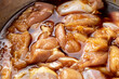 鶏肉の唐揚げ調理シーン。鶏もも肉に下味をつけるため、タレに漬け込む。
