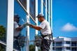 © Oleksandr Kozak - Facade worker clean up the house windows of modern building with a clear blue sky