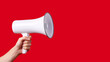A man's hand holds a megaphone announcing the start of the Black Friday sale. Red background with copy space