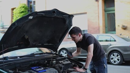 Wall Mural - A young guy repairs the headlight of a car.