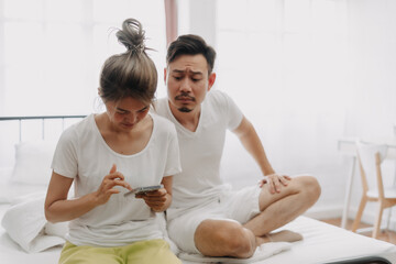 Wall Mural - Asian husband peeking wife chatting on the phone if she might has an affair.