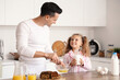 © Pixel-Shot - Cute little girl with her dad making breakfast in kitchen