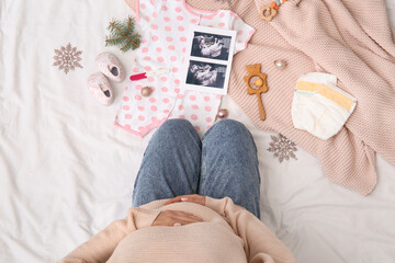 Sticker - Pregnant woman with sonogram image, baby accessories and Christmas decorations on bed