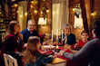 © Drazen - Happy multigeneration family talks during Christmas dinner at dining table.