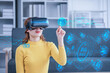 © wichayada - Attractive Asian woman shopping for online discount campaign in virtual reality through VR glasses on the sofa having fun and entertainment time in your home living room.