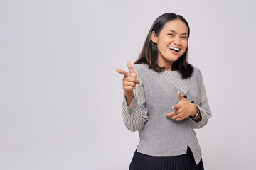 Wall Mural - Smiling beautiful young Asian woman in casual clothes pointing fingers aside at copy space for your advertisement isolated on white background. People lifestyle concept