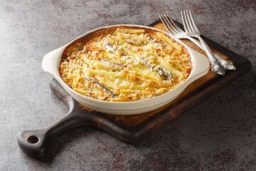 Janssons frestelse or Jansson's temptation is a creamy potato casserole traditionally served at Christmas in Sweden closeup on the baking dish on the table. Horizontal