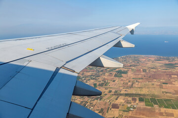 Wall Mural - Plane flying over Greece. Greek island and blue Aegean sea water view out of airplane window.
