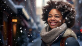Fototapeta  - Mujer afroamericana de pie con un fular en el cuello y pelo voluminoso, sonriendo en un día nevado en la ciudad.