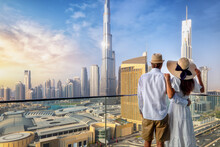 A Couple On Holidays Enjoys The Panoramic View Over The City Skyline Of Dubai, UAE, During Sunrise