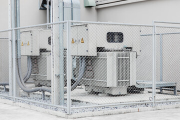 Electricity transformer high voltage Three phase electric power with safety area fence protection zone in industry building.