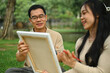 © Prathankarnpap - Smiling middle age man and adult daughter painting on canvas enjoying free time at green park