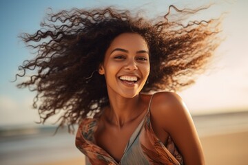 Wall Mural - a young and beutiful african american woman embracing the liberating feeling of joy as she runs along the beach, the wind tousling her hair