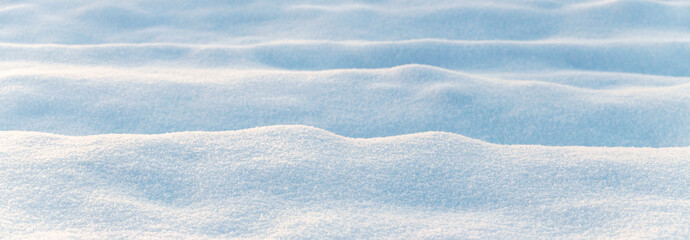 Wall Mural - Winter background with snow-covered wavy uneven ground surface, snow texture