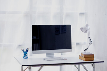 Wall Mural - Laptop Computer, notebook, and eyeglasses sitting on a desk in a large open plan office space after working hours	