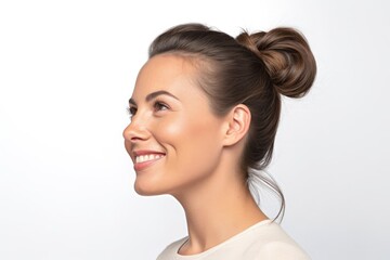 Young beautiful brunette woman with short hair and toothy smile on white background, close up profile portrait.