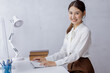 © David - Attractive smiling young asian business woman work in the office, Asian woman working on laptop computer holding tablet.