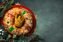 Top View Of Roscon De Reyes With Cream And Crown Of The Three Wise Men On A Red Plate With Space For Text. Kings Day Concept Spanish Three Kings Cake