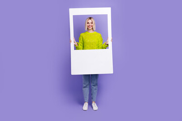 Sticker - Full length photo of excited funky lady wear green pullover holding paper frame isolated purple color background