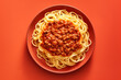 Spaghetti bolognese with fresh basil in a yellow bowl on red background. Top down view. Traditional Italian cuisine