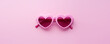 Valentines day or summer concept. Heart shaped sunglasses on pink background.