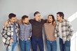 © Studio Romantic - Portrait of a male mature bearded friends looking cheerful at each other and smiling on grey wall background. Photo of a group of brutal friendly men hugging and laughing in casual clothes.