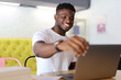 © Andrii Zastrozhnov - Happy and confident African American businessman working with a laptop in a modern office, reflecting success and a positive professional attitude.