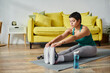 © LIGHTFIELD STUDIOS - young good looking woman stretching her muscles actively on floor at home, fitness and sport