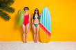 Photo of two best friends girls hold surfing board buoy enjoy extreme water sport on exotic coast isolated over shine color background