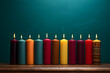 The kinara candles for Kwanzaa are positioned against a solid colored wall,