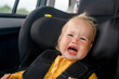 Children's hysteria in the car, the child cries and screams in the car seat on the trip