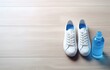 © Oleksiy - white sneakers and bottle of water on white wooden floor near window for sport fitness card design