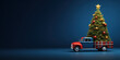 Old truck arriving with fresh Christmas tree on dark blue background with copy space