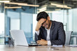 © Liubomir - Depression at workplace, businessman disappointed with achievement results sad in despair inside office, man in business suit unhappy working with laptop.