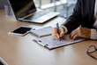 © Liubomir - Businessman hands close up, man fills tables inside office at workplace, employee financier on paper work, uses calculator and laptop, selected focus.