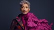 Queer, Transgender, Asian, Nonbinary, Trans Woman Portrait wearing Black Floral Suit and Silk Pink Fuchsia Tia Boa with Short Gray Hair in front of Dark Studio Background with Room for Copy Text