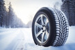Brand new winter car tires showcased against a snowy road background.
