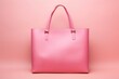 pink tote bag with a smooth finish and sturdy straps, centrally positioned against a matching pink backdrop for a seamless look