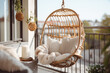 Cozy boho style balcony interior design with swinging chair, natural decoration and potted green plants