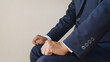 手をグーにして正しい姿勢で座るビジネスマン｜面接・商談などで待機するイメージ