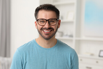 Canvas Print - Portrait of happy man in stylish glasses at home