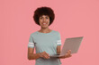 © New Africa - Beautiful young woman with laptop on pink background
