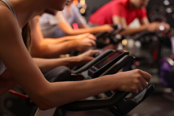 Sticker - Group of people training on exercise bikes in fitness club, closeup