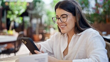 Canvas Print - Young beautiful hispanic woman smiling happy speaking on the phone sitting on the table at bar terrace