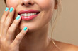 © vectorfusionart - Caucasian woman wearing natural makeup and blue nail polish on beige background