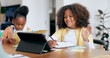 © Charlize D/peopleimages.com - Children, e learning and tablet with writing, wave hello or book for education, development or study at desk. Kids, touchscreen and notebook with smile, online course and home school in family house