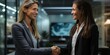 © Riverland Studio - a smiling business woman shaking hands with a female consultant in office