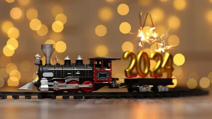 Wall Mural - The train delivers the figures of the upcoming new year as cargo. The inscription 2024 sparkling with cheerful sparks.